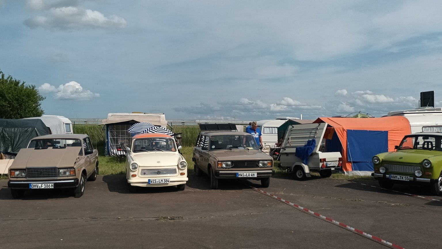 Reihe bunt lackierter Trabant-Oldtimer auf dem Flugplatz von Anklam beim Trabi-Treffen 2025