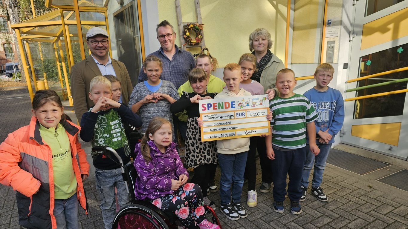 Personen lächeln bei einer Spendenübergabe für einen guten Zweck