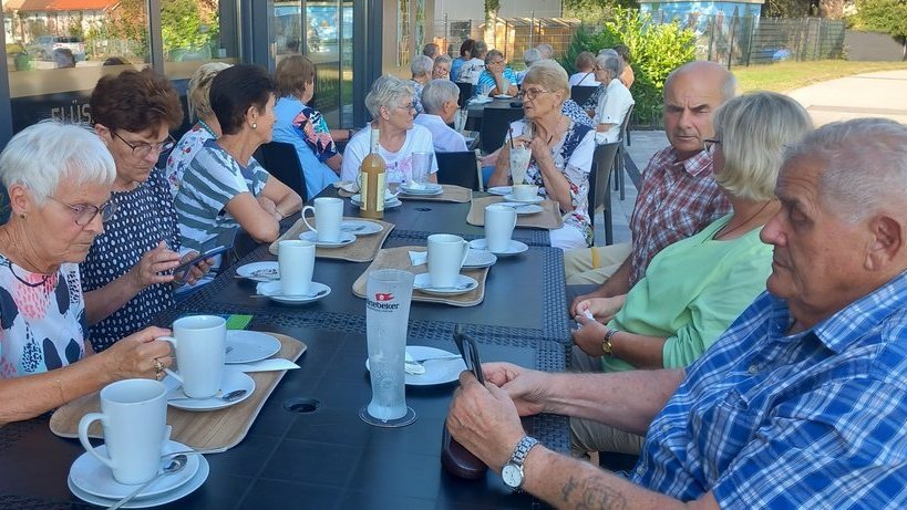 Teilnehmer sitzen im Café der Ölmühle bei Kaffee und Kuchen