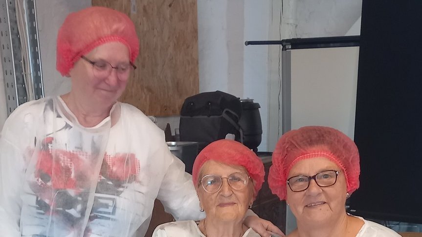 Drei Seniorinnen lächeln in die Kamera