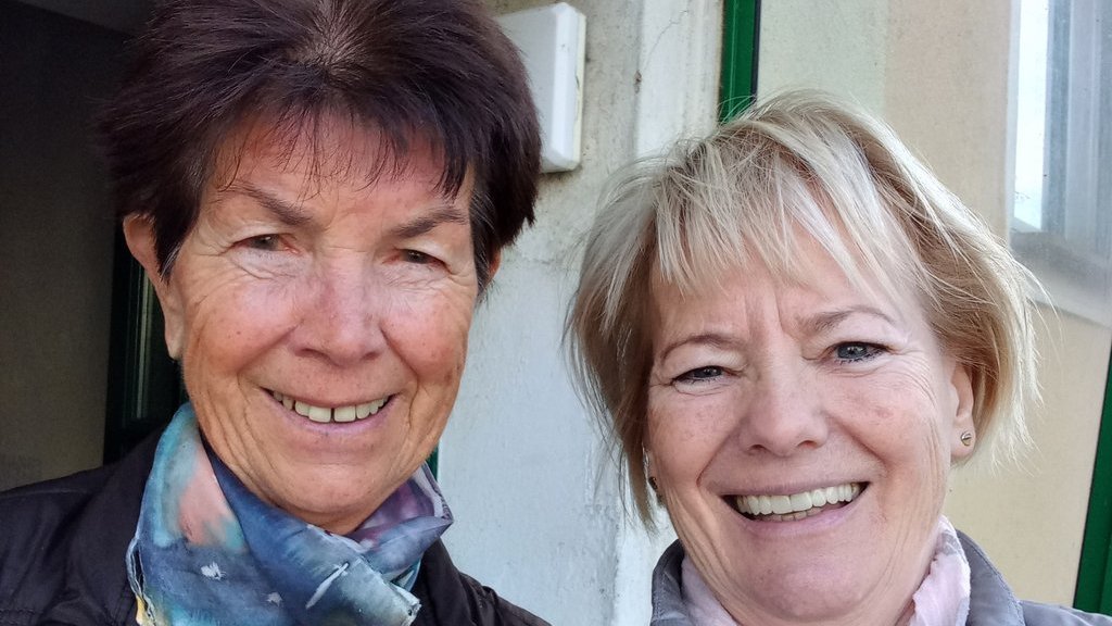 Zwei Seniorinnen lächeln in die Kamera