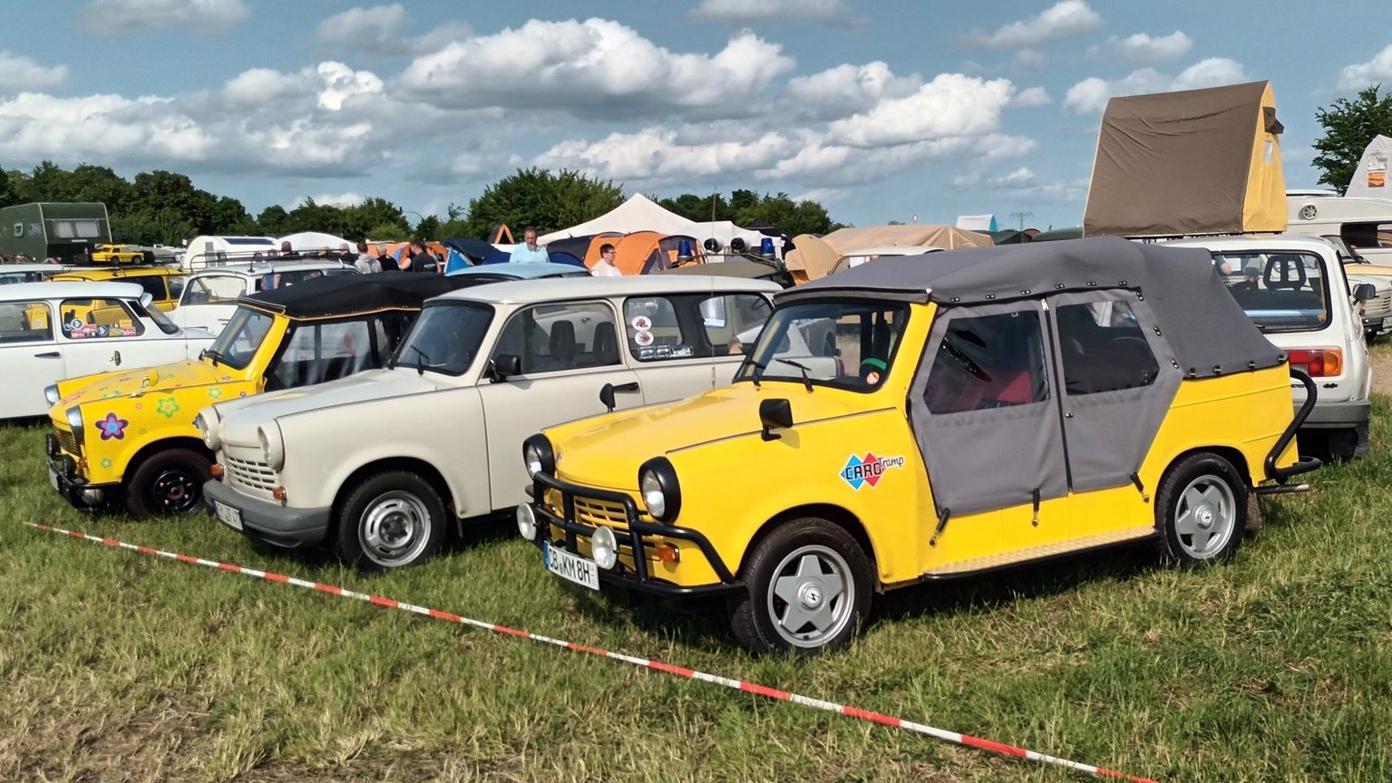 Bunte Trabant‑Modelle, unter anderem in Weiß, Grau und Gelb, nebeneinander auf dem Treffen in Anklam